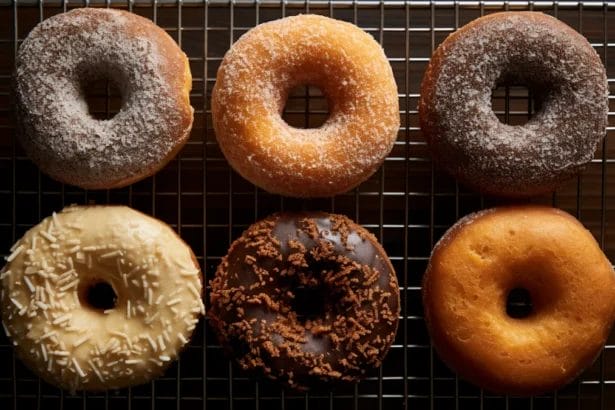 Assortment Of Six Artisanal Doughnuts On A Cooling Rack