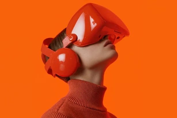 Person In Red Vr Headset With Headphones Against Orange Background.