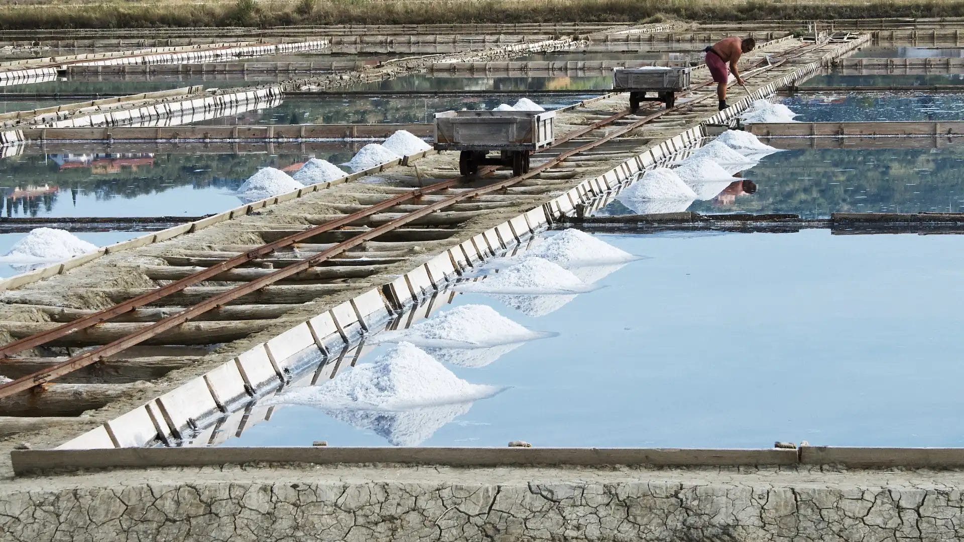 Man On Track At A Salt Production Site By A Lake