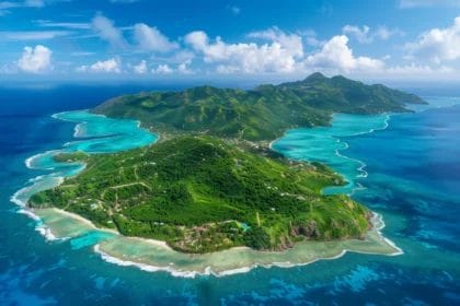 Aerial View Of A Tropical Island With Turquoise Waters And Green Hills.